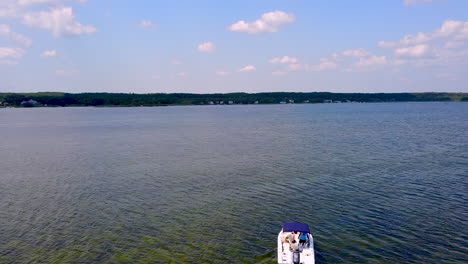 Drone-Siguiendo-Un-Pequeño-Barco-Pesquero-En-Una-Bahía-Local-Frente-Al-Océano