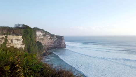 blue ocean with stone rock cliff at uluwatu bali indonesia asia with big waves and clear blue sky ocean scape