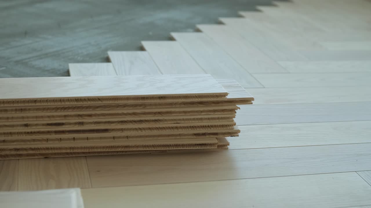 trabajador instalando pisos de madera con martillo y bloque de golpeo