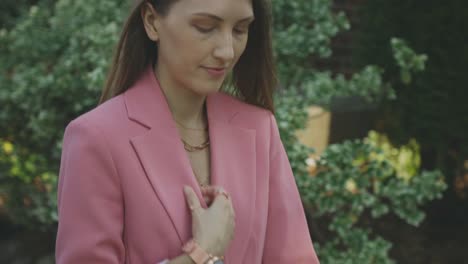 A-Young-Professional-Caucasian-Woman-In-Pink-Blazer-Walking-Down-The-Street-Pavement---Tracking-Shot