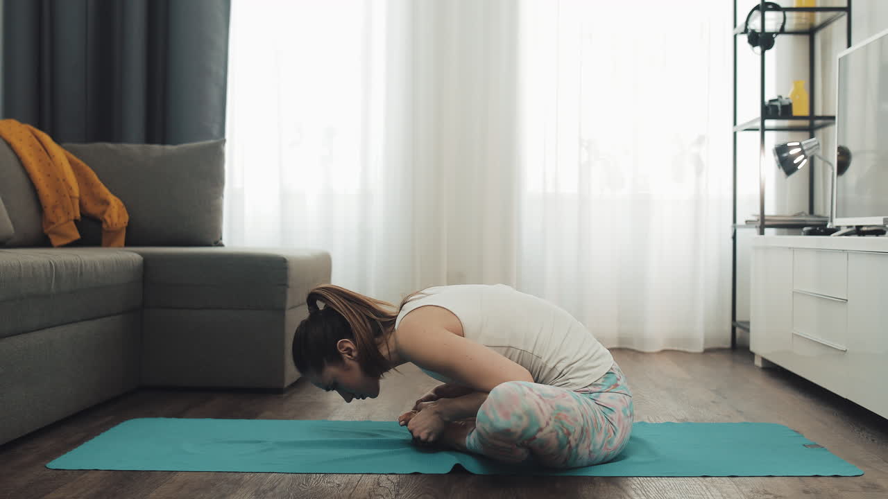 Woman doing yoga butterfly stretch at home
