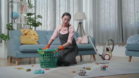 woman cleaning a messy living room with toys