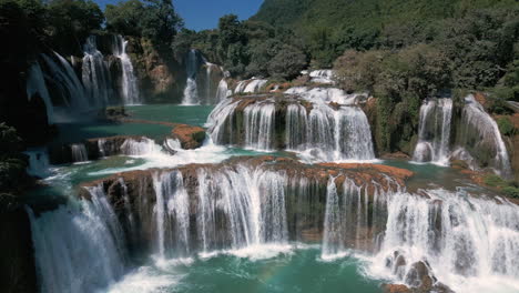 stunning aerial view of a multi-tiered waterfall in lush forest