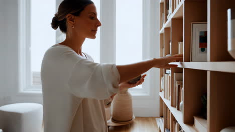 woman organizing books on a bookshelf