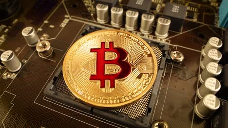 Gold-Bit-Coin-BTC-coins-on-the-motherboard.-Bitcoin-is-a-worldwide-cryptocurrency-and-digital-payment-system-called-the-first-decentralized-digital-currency.