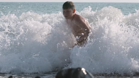 boy playing in the waves at the beach