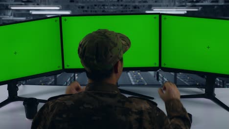 vista trasera de feliz ejército asiático celebrando mientras trabajaba con simulacro de múltiples monitores de computadora en el centro de datos