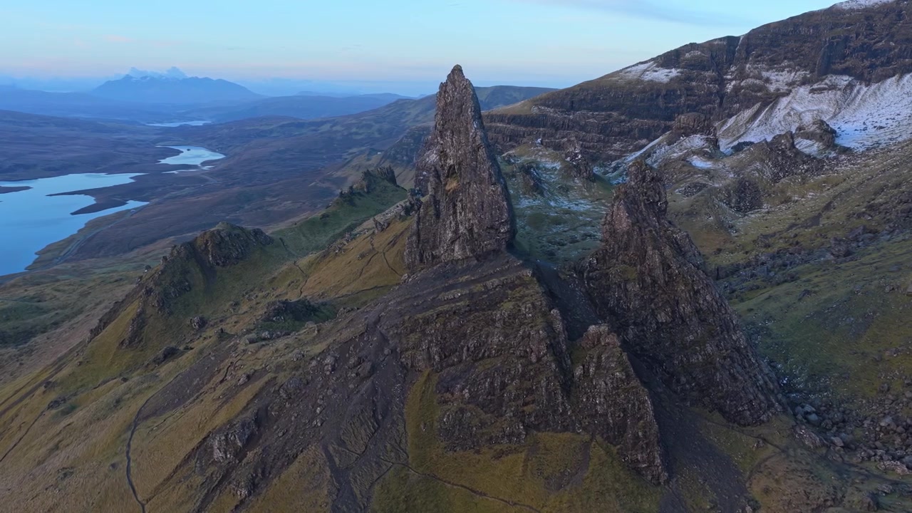 Majestätisk flygfilm som kretsar kring Old Man of Storr, en berömd klippformation på Isle of Skye med hisnande skotskt höglandskap.
