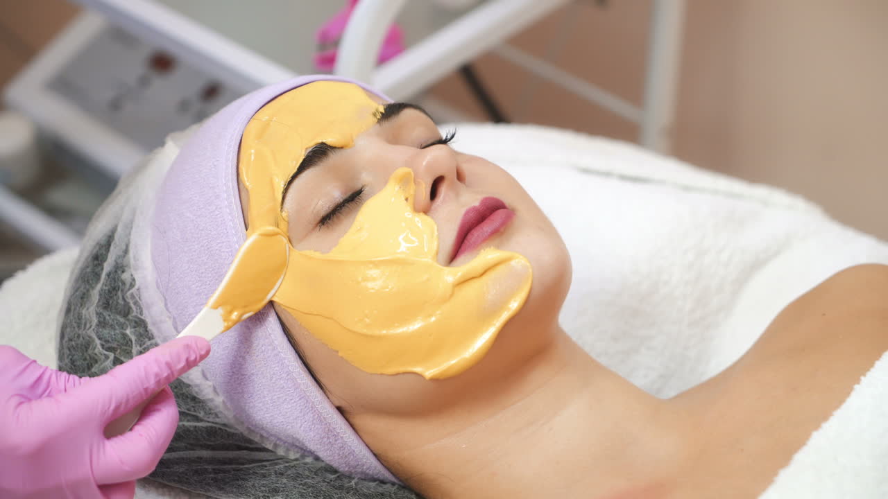 Giovane donna riceve iniezioni estetiche al viso in un centro estetico. Cosmetologia estetica. Applicazione di maschera facciale nella spa.