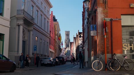 a quiet street in bruges with colorful buildings, bicycles, and a van in the morning light