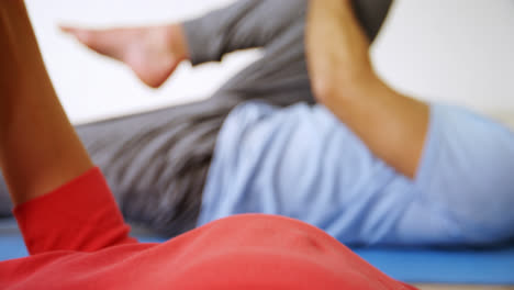 man and woman doing leg stretching exercise at fitness studio 4k