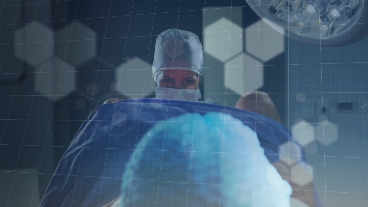 병원 수술실에서 아기를 출산하는 두 인종의 여성 의사에 대한 보케 조명