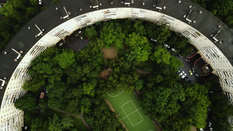 Aerial-view-flying-over-a-Bublik-Circular-House,-summer-evening-in-Moscow,-Russia---top-down,-drone-shot