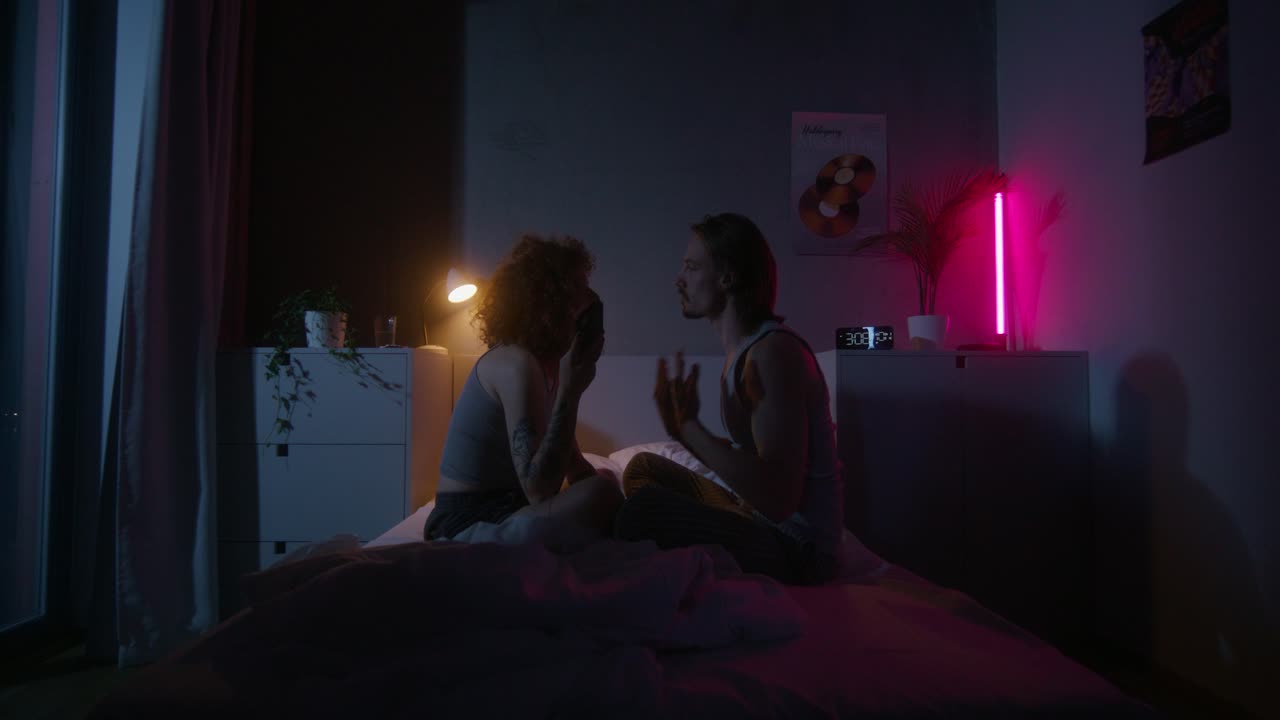 밤에 침대에서 대화하는 커플