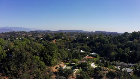 Aerial-rising-shot-of-a-hills-community-above-Sherman-Oaks-with-fresh-water-reservoir