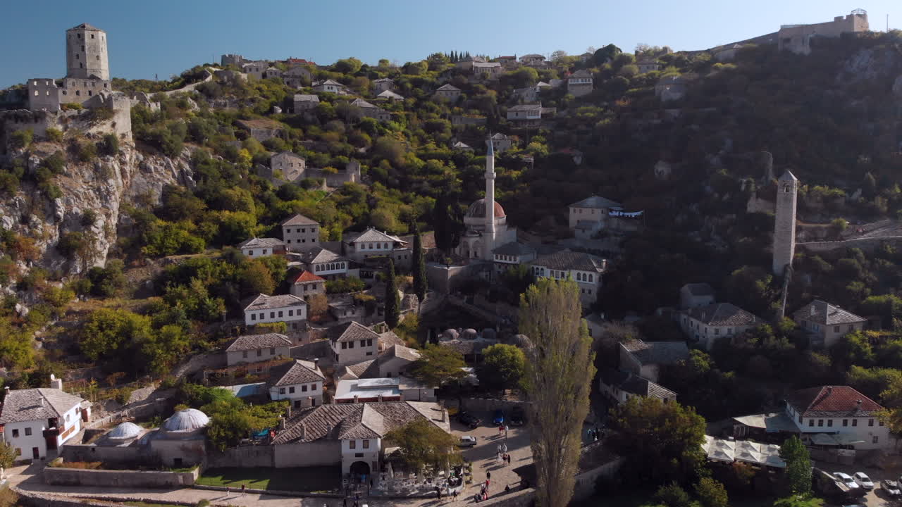 Mosque and historic buildings in Počitelj town, Bosnia, aerial pull-away reveal