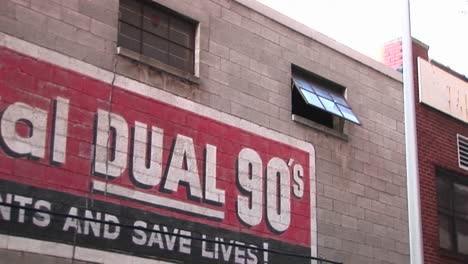 the camera zooms in on an open window past advertising on an old building