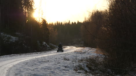 little kid rides quad bike alone on rural winter road