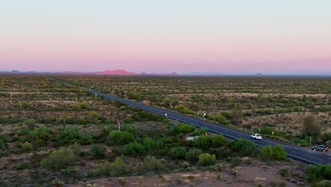 Car-rides-in-scenic-purple-sunset-landscape-in-Arizona-desert,-Grand-Canyon