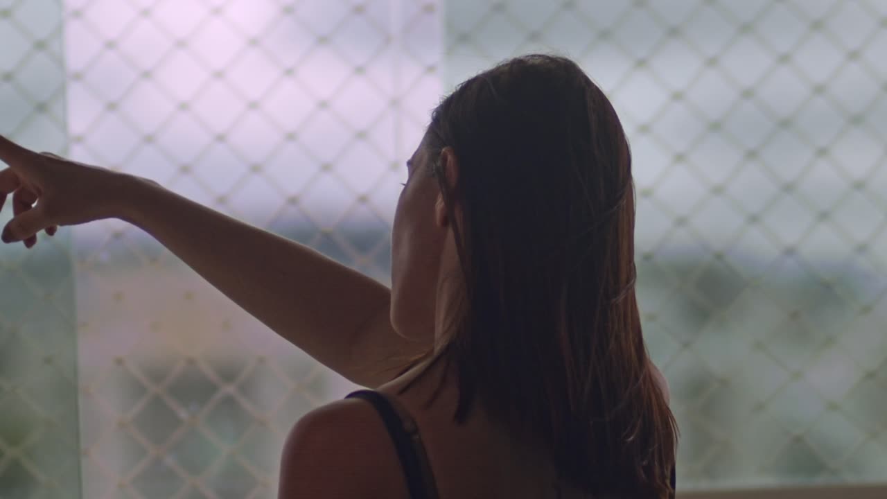 아파트 창 밖을 가리키는 갈색 머리 여자의 뒤, 슬로우 모션