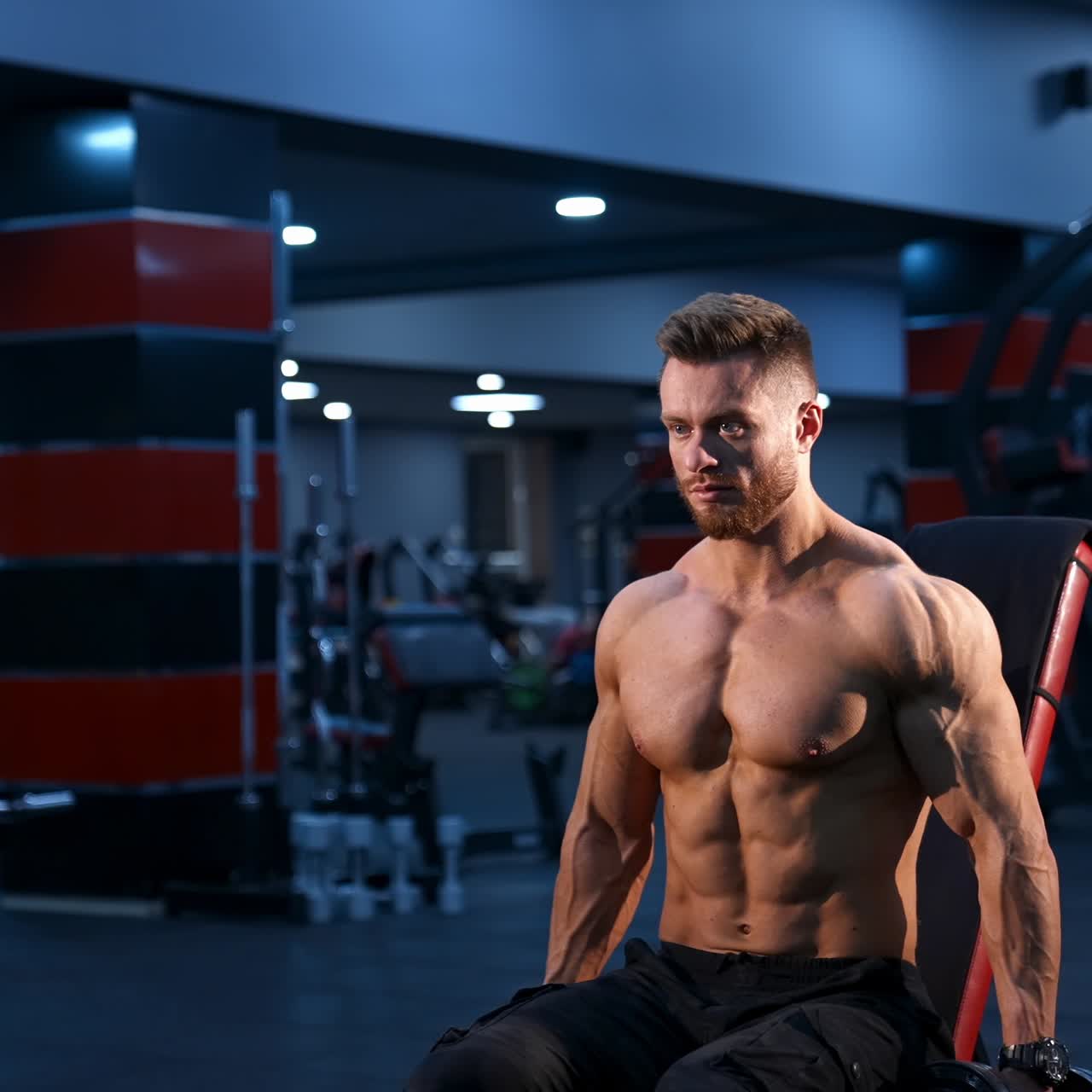 Handsome power athletic man bodybuilder doing exercises with dumbbells. Fitness muscular body on dark gym background