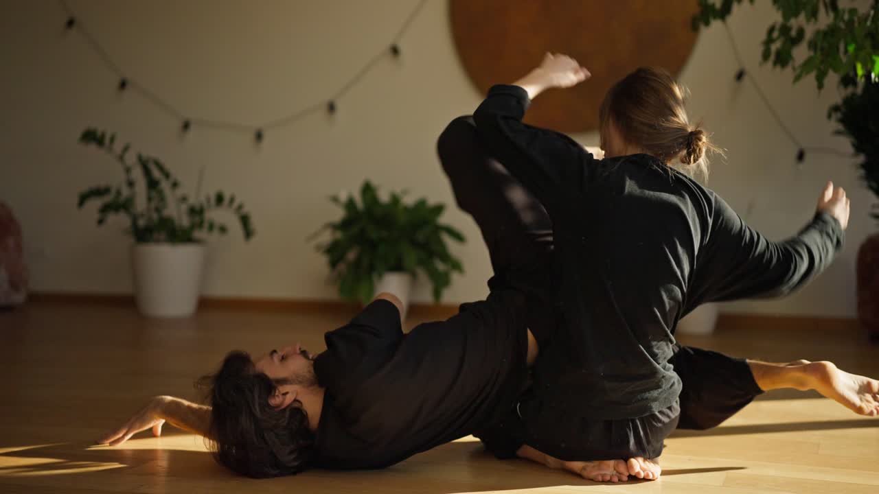 Casal praticando acroyoga em um local fechado