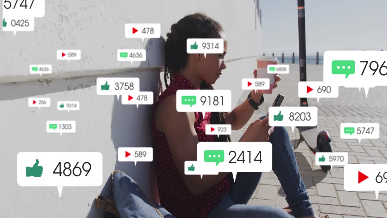 animación de iconos de las redes sociales sobre una mujer biracial bebiendo café usando un teléfono inteligente en el paseo marítimo