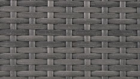 tightly framed shot reveals the intricate braided strands of a dark wicker chair