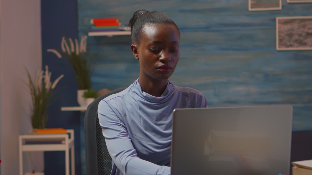 African-american woman looking at camera smiling working at pc