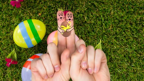 animación de manos con dibujos de conejo con huevo de pascua sobre huevos de pascua en la hierba