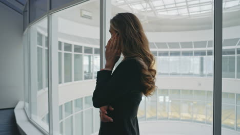 Serious businesswoman speaking cellphone in office. Stressed woman discussing