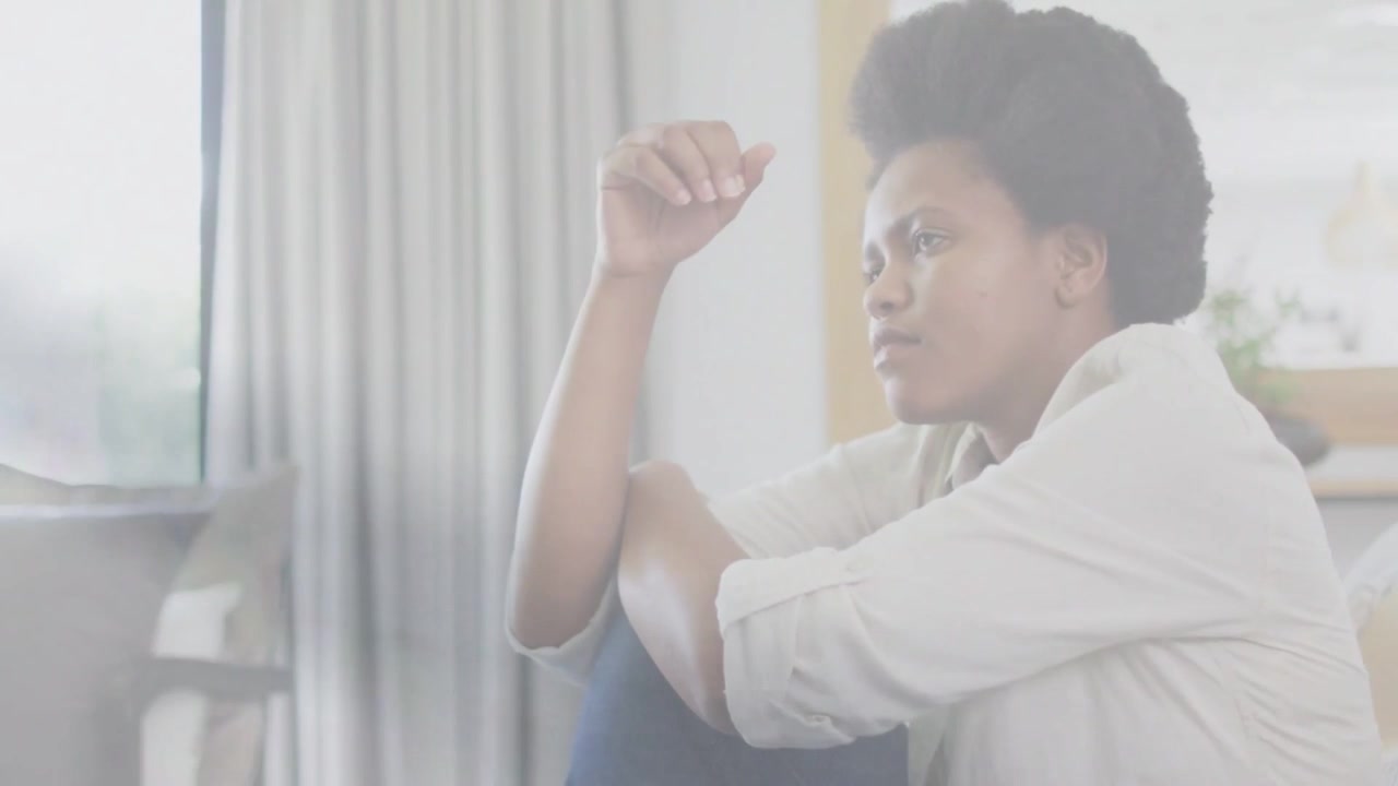 Vertical video: Woman gazing window shifting hand to hair to calm while health HUD tracking breath