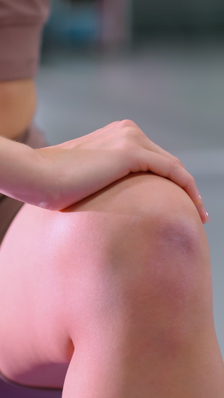 깊은 스트레칭 운동을 수행하는 여성의 아래쪽 몸의 근접 뷰, 균형을 위해 무에 손을 고, 튼튼한 다리, 유연성 및 적절한 자세에 초점을 맞추십시오.