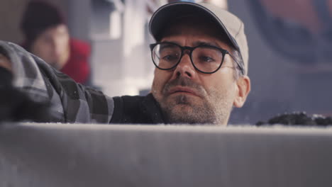 man inspecting or working with stone block