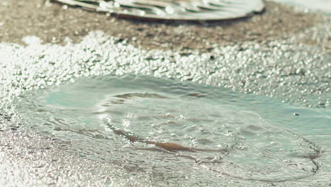 girl in pink rubber boots runs and jumps in large puddles