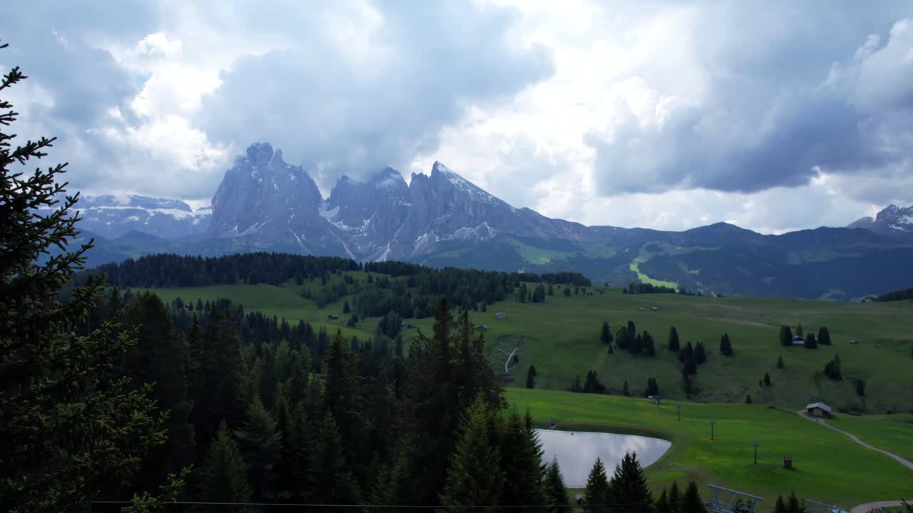 el vuelo de un avión no tripulado a través de los árboles del bosque revela el paisaje montañoso del alpe di siusi