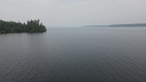 Flying-Above-Idyllic-Lake-On-A-Foggy-Day---drone-shot