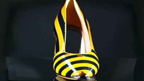 a pair of yellow and black striped shoes on a black surface