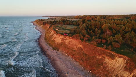 baltic cliffs glow at dusk as rooftop camper enjoys wild coast near jūrkalne