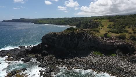 flying backward over a cliff on the coast of maui, hawaii on a sunny day, reverse dolly