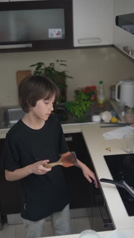 a child cooking pancakes in the kitchen