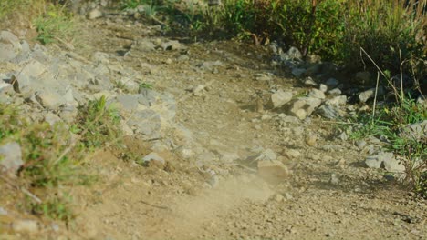 una bicicleta de montaña se desliza y levanta rocas a cámara lenta