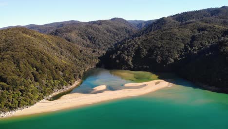 sandy beach across sandfly bay aerial fly backward shot reveal of beautiful landscape of abel tasman