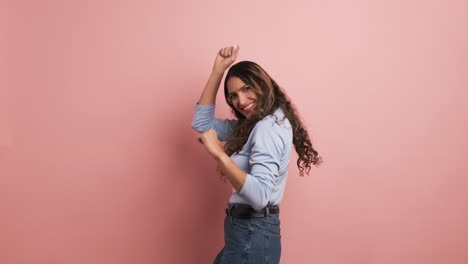 happy woman dancing while looking at camera