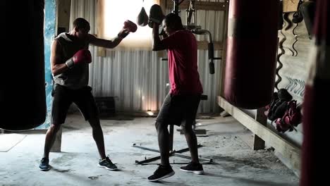 entrenador y boxeador practicando boxeo en el gimnasio