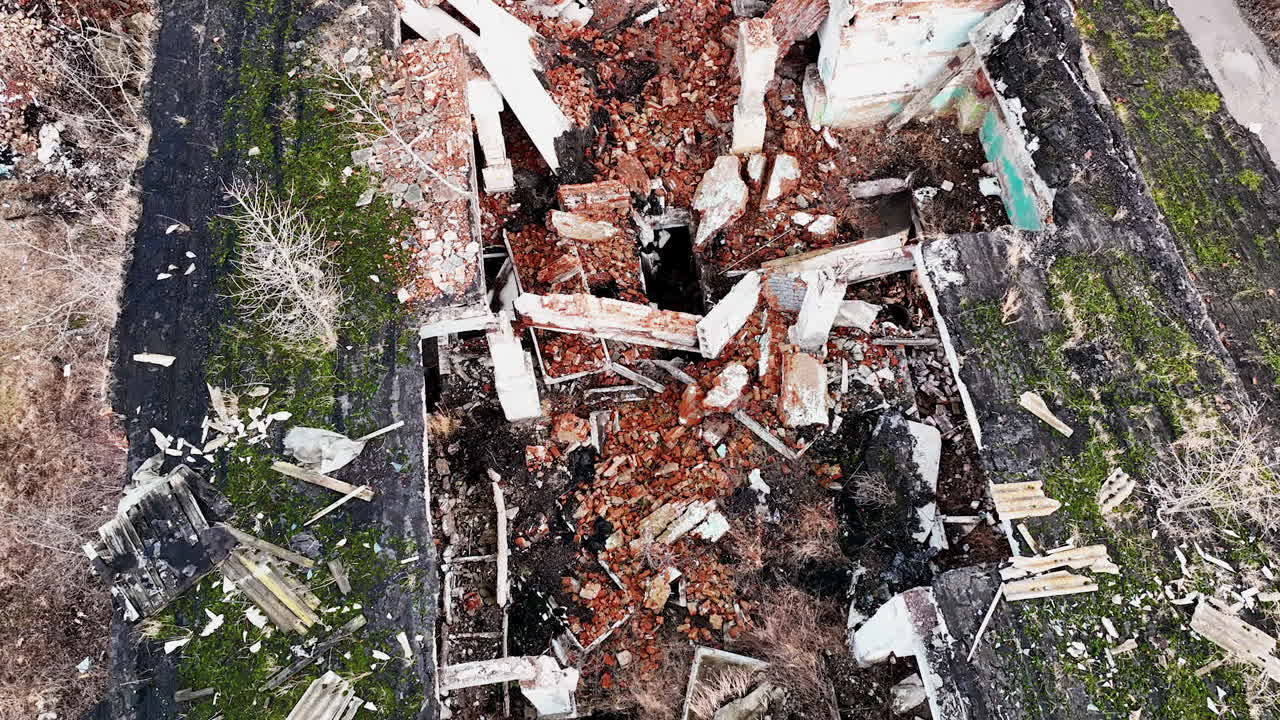 Collapsed ruins of the old building. Bricks, stones and pieces of concrete left after the house bombing. Aerial view.