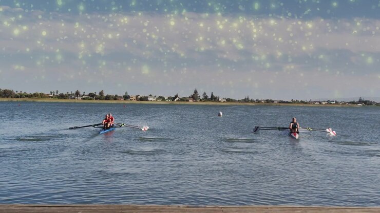Two scullers starting training strokes, powering boats by white buoy with star overlay above rowers