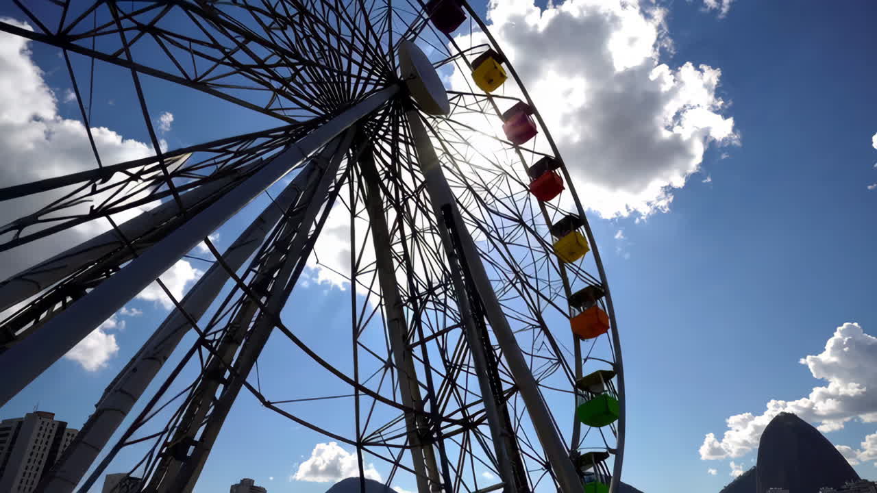 Large Ferris wheel against a bright blue sky with clouds
