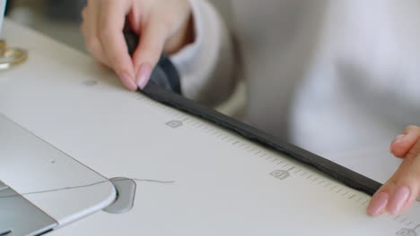 바느질기 바늘은 움직이고, 바느질기의 바늘은 빠르게 위아래로 움직이고, 매는 사람이 바느질 작업장에서 검은색 천을 는다.