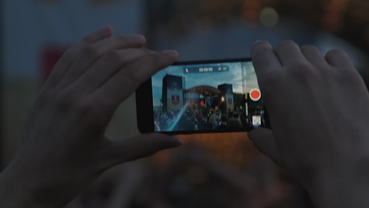 스마트폰으로 라이브 음악 콘서트의 사진을 찍거나 비디오를 녹음하는 손 실루 사진, 엔터테인먼트 및 기술 개념